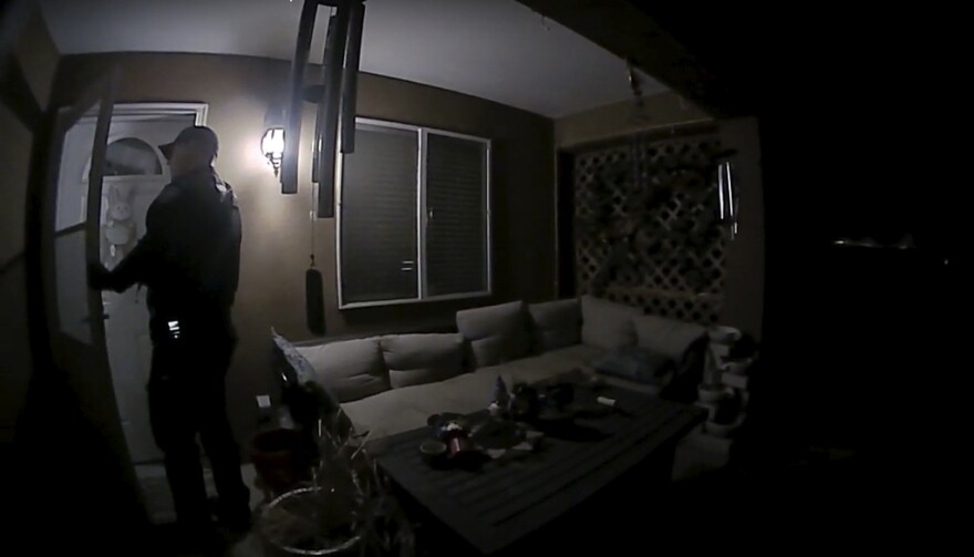 In this image taken from body camera video provided by the Farmington Police Department, a police officer knocks on the door of the wrong address in response to a domestic violence call, in Farmington, N.M., late April 5, 2023. Moments later, the homeowner was fatally shot by police after appearing at the door armed with a handgun. (Farmington Police Department via AP)
