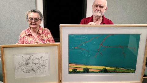 Nancy and Fred Jones at the TSPR studios. Nancy is holding one of her works, “Growth,” and Fred is displaying his piece “Lightning Hits Old Mississippi."