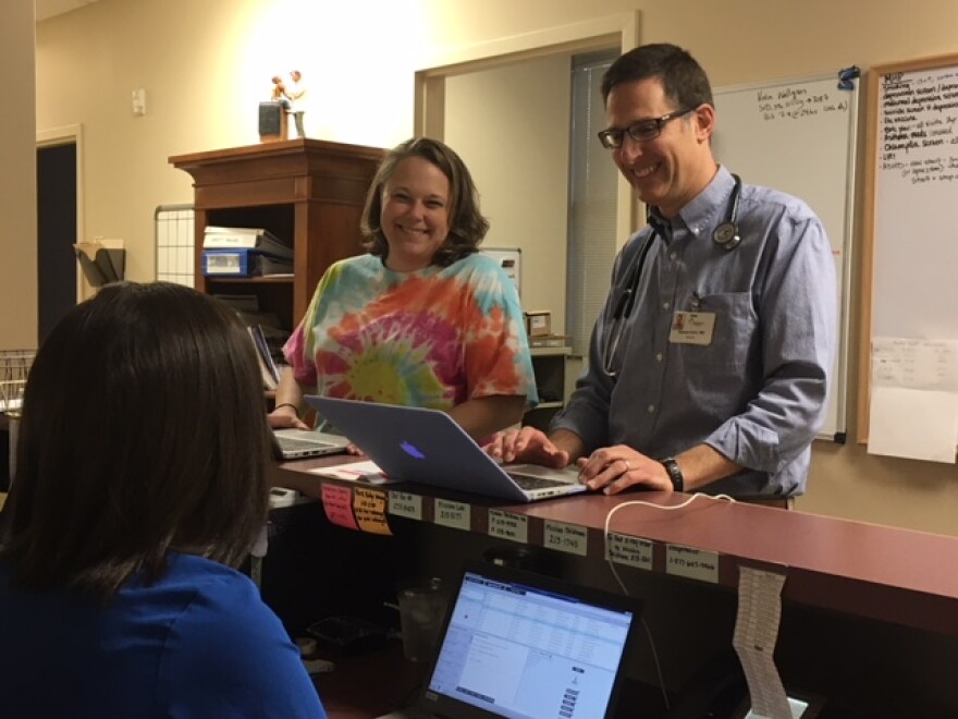 Dr. Sam Kohn in his office with staff .
