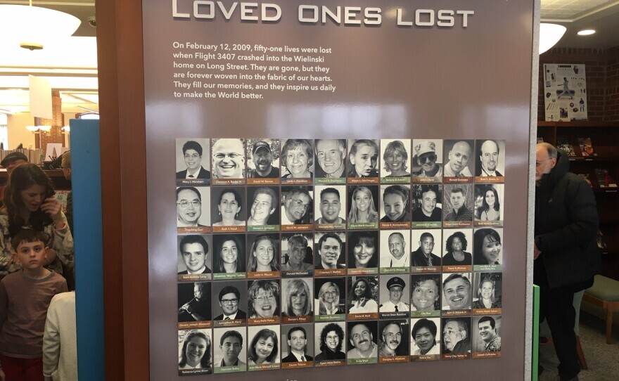 A brown and white plaque with photos of "Loved Ones Lost" in the crash of Flight 3407.