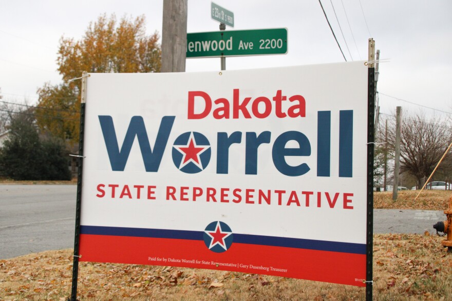 A red, white and blue sign that says "Dakota Worrell State Representative"