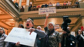 Protestors hold signs and shout against the push to redistrict in Indiana at the statehouse on Monday, Dec. 1, 2025 after the Indiana House released its new proposed map.
