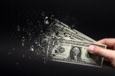  One dollar bill is sprayed in the hand of a man on a black background. 