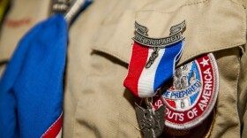 Close up of Eagle Scout badge pinned to the chest of a boy scout in uniform.