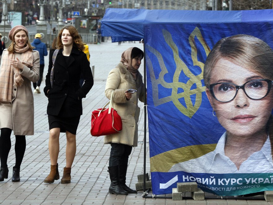 Passersby walk past a tent in support of former Prime Minister Yulia Tymoshenko in Kiev on March 26. None of the 39 presidential hopefuls are expected to win an outright majority in Sunday's vote, meaning a likely runoff.