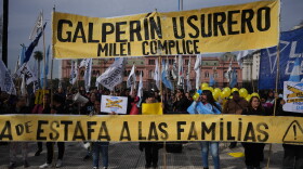 Demonstrators hold a banner with a message that reads in Spanish: "Galperin loan shark, Milei an accomplice" outside the Economy Ministry to demand government action over a household debt crisis in Buenos Aires, Argentina, Thursday, Aug. 20, 2026.