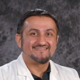 Dr. Ammar Husan is pictured in a white LSU Health physician's coat