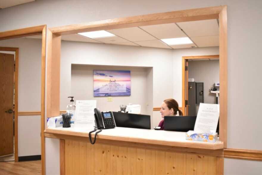 Medical assistant Sarah Martin sits at the reception desk of Ideal Option, a medication assisted addiction treatment clinic in Juneau. In Dec. 2019, the Alaska Department of Health and Social Services released a new guide for offering medication assisted treatment to patients. (Photo by Kavitha George/KTOO)