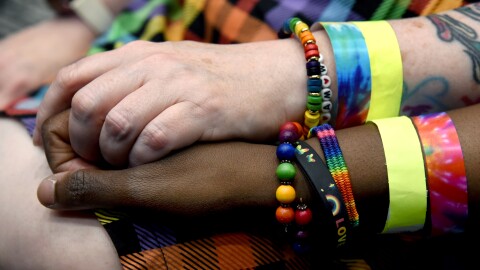 GREELEY, CO: (From left) Chrysta Bairre and Jamila Bryant hold hands while listening to speakers at Greeley Pride. Sonya Doctorian/KUNC