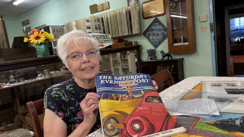 Julie Miller, curator of the Edwards County Historical Society Museum and Sod House Museum, with the famous Saturday Evening Post cover.