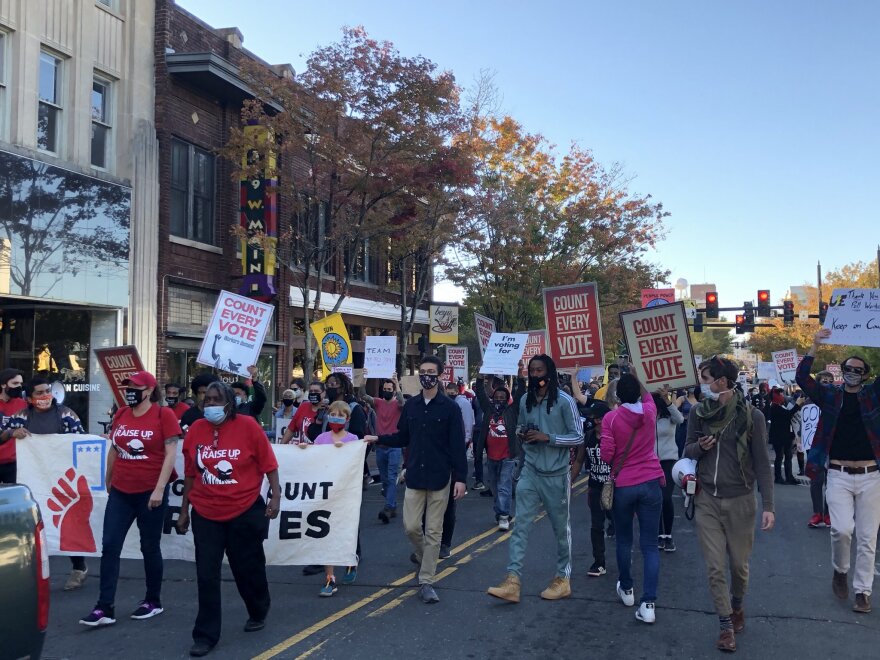 Demonstrators march around downtown Durham Wednesday afternoon calling for a proper tally of all ballots cast in Tuesday's election.