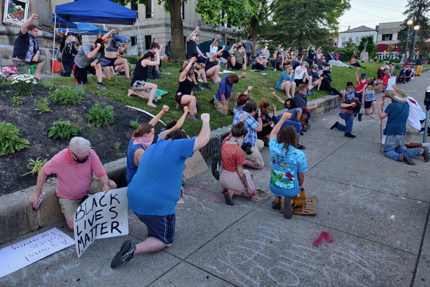 Demonstrators kneel in downtown Bloomington.