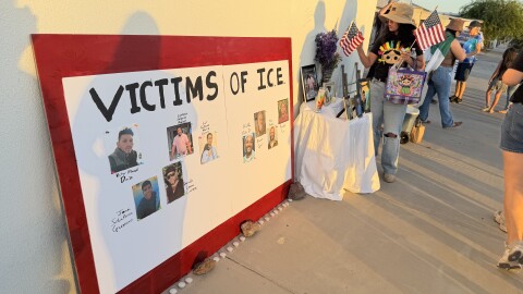 San Luis artist Emilia Verdugo places American flags on an altar for people killed by ICE officers since 2025 before a community vigil in Yuma on Wednesday, July 15, 2026.