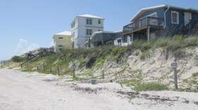 In Satellite Beach, homes perch atop a sand dune, left exposed after a series of storms and hurricanes washed away a sea wall.