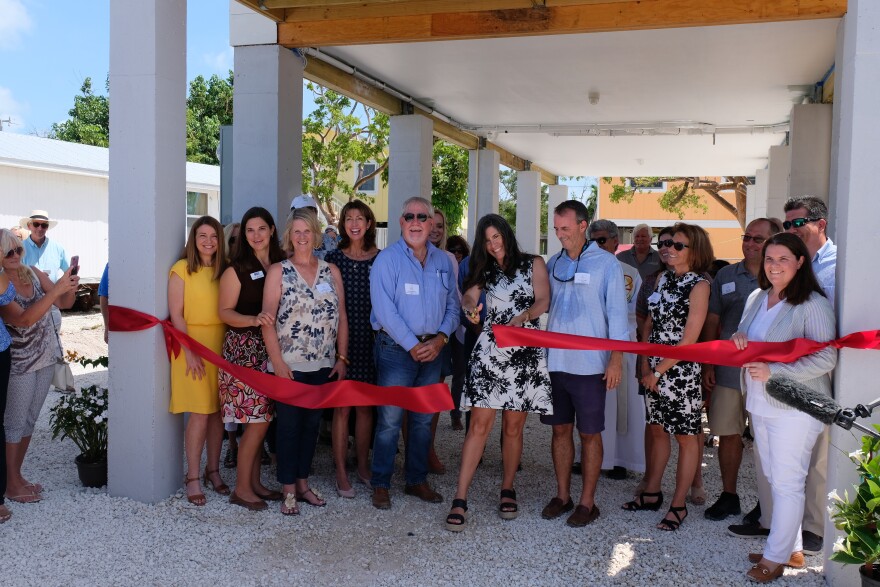 Maggie Whitcomb, the founder of the Florida Keys Community Land Trust, cuts the ribbon on the group's first home completed on Big Pine Key.