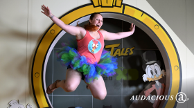 A woman jumps into the money pit at the Duck Tales exhibit during the D23 expo fan convention.