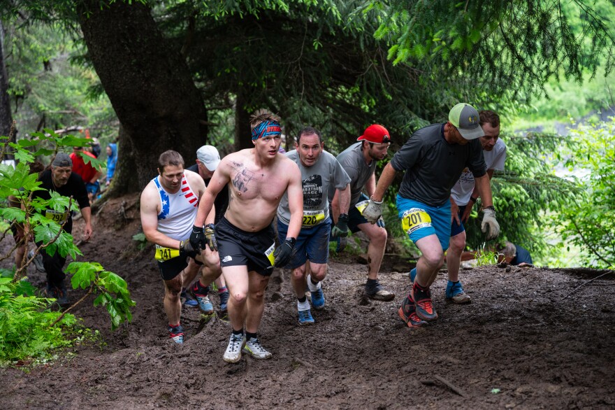 A group of men hiking a muddy trail.