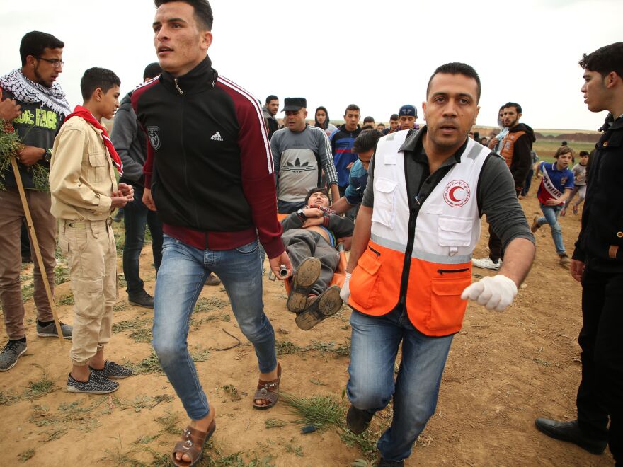 A Palestinian youth is carried on a stretcher Friday after being injured during a demonstration near the border with Israel east of Jabalia in Gaza.