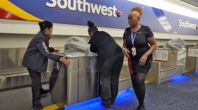 Southwest Airlines employees cover the ticket counters with plastic wrap.