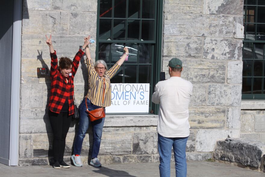 Brook McDermott, (L), Debra Condon and Jeff Hamilton (taking their photo) in front of the National Women's Hall of Fame in Seneca Falls on Saturday.