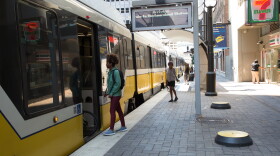  Passengers board a DART light rail train at a station in downtown Dallas.