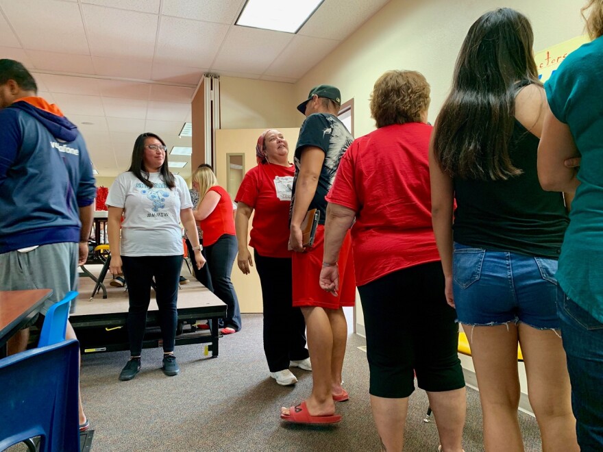 People stand in a group waiting for the conference to begin. 