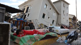 A boy sleeps outside earthquake-damaged homes in Catia La Mar, Venezuela, Sunday, June 28, 2026.