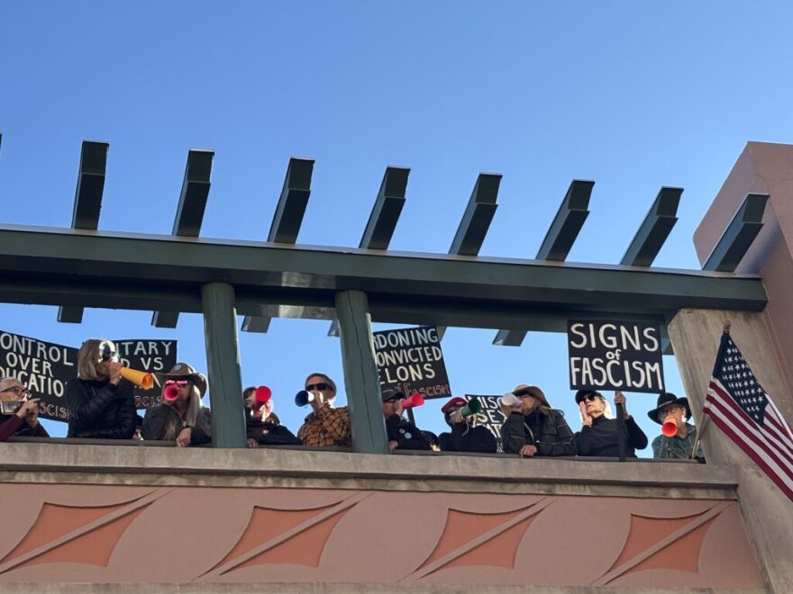 Protesters gathered atop the parking garage across the street from the Lensic Performing Arts Center in Santa Fe, NM on March 8, 2026, during an event featuring U.S. Supreme Court Justice Amy Coney Barrett. (Julia Goldberg/Source NM)