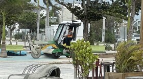 A Fort Myers Beach town worker sweeps sand from Lynn Hall Park on Monday after Tropical Depression Debby brushed the coastline.