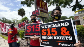 FILE - Workers and family members take part in a 15-city walkout to demand $15hr wages Wednesday, May 19, 2021, in front of a McDonald's restaurant in Sanford, Fla.