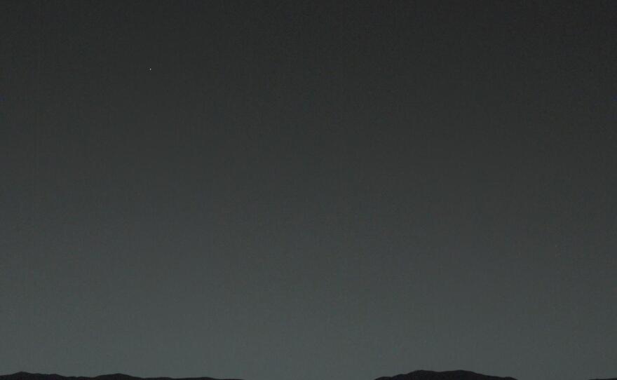 Trust us, there is a tiny dot over the Mars horizon and it is Earth. The next slide will make it easier to see what the Curiosity rover captured with its camera from 99 million miles away.