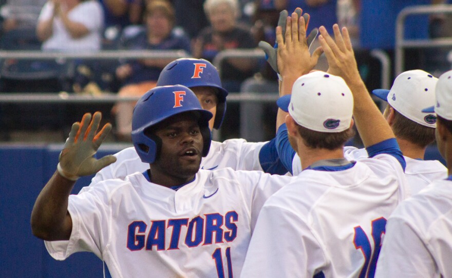 Josh Tobias and JJ Schwarz are welcomed by teammates at the dugout after scoring the last two runs of the first inning against FSU on June 5.