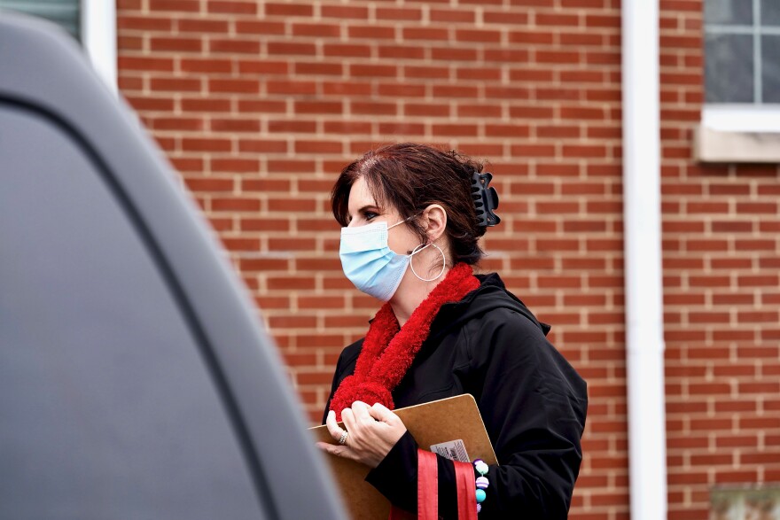 St. Matthews Area Ministries executive director Julie Abbott speaks with a person using their drive-thru food distribution services on Dec. 8, 2020.