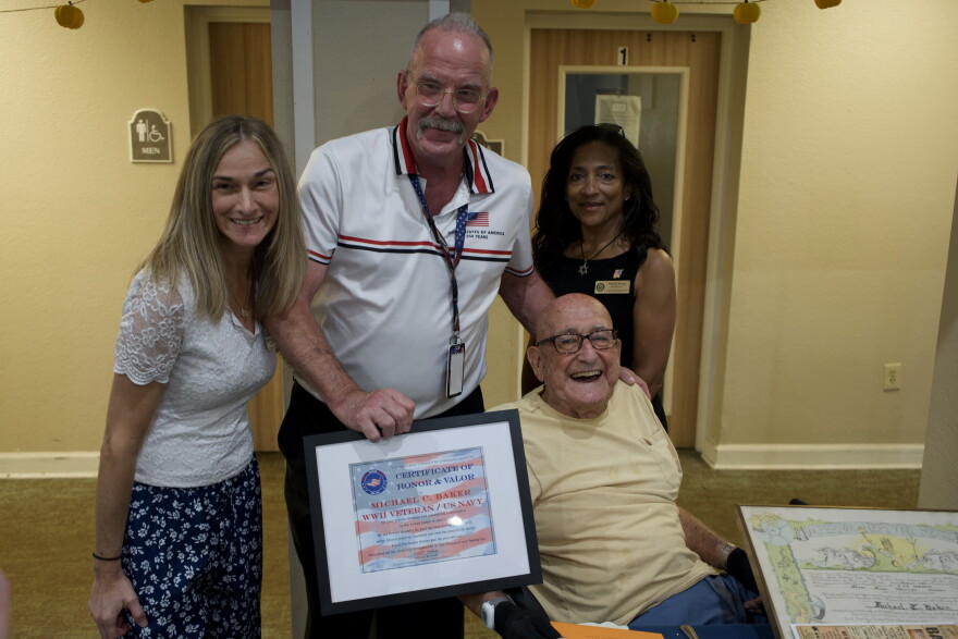 Michael Baker, bottom right, is presented with a Certificate of Honor & Valor pictured with Pratima Strong, top right, Todd Belknap, center, and Shelly Weinhart, top left.
