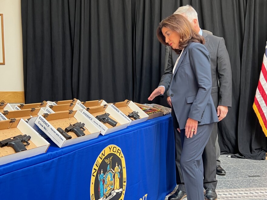  Governor Kathy Hochul surveys a cache of illegal weapons seized by state police on August 4, 2022. 