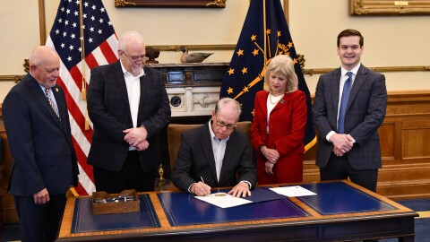 State representatives Doug Miller and Matt Lehman, State Senator Liz Brown and Allen County Director of Government Affairs John Wilson flank Governor Mike Braun (seated) as he signs a public access bill into law.