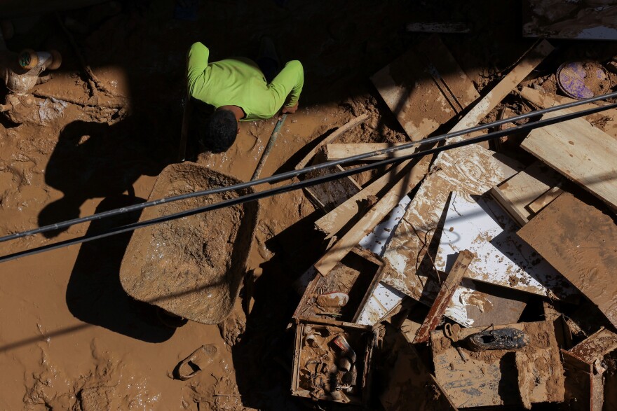 A person removes mud from a house after floods in Derna, Sept. 19.