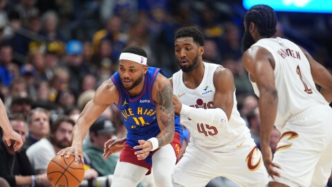 Denver Nuggets guard Bruce Brown, left, collects a loose ball as Cleveland Cavaliers guards Donovan Mitchell, center, and James Harden defend in the second half of an NBA basketball game, Monday, Feb. 9, 2026, in Denver. 