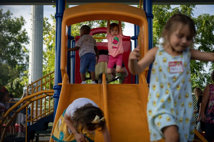 Matea Tilden hangs from the slide at the Affton Early Childhood Center Tuesday, Aug. 13, 2019, on her first day of school.