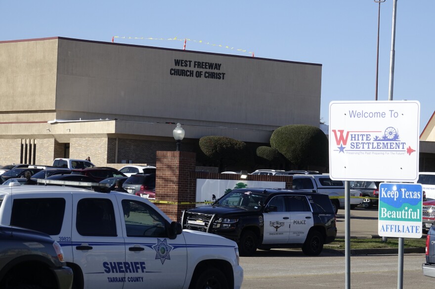 Law enforcement vehicles are seen parked outside West Freeway Church of Christ as authorities continue to investigate a fatal shooting at the church on Sunday, in White Settlement, Texas.