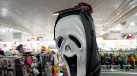 A scary mask stands on a shelf in the costume store "Haertels Faschingswelt".