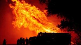 Butte county firefighters watch as flames tower over their truck during the Bear fire in Oroville, California on September 9, 2020. (JOSH EDELSON/AFP via Getty Images)
