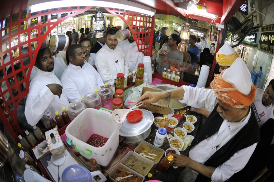 Men line up at a takeaway food stand in the Saudi port of Jeddah in the early hours of August 26, 2011. Practicing Muslims eat their<em> suhoor </em>meal before dawn during the holy fasting month of Ramadan.