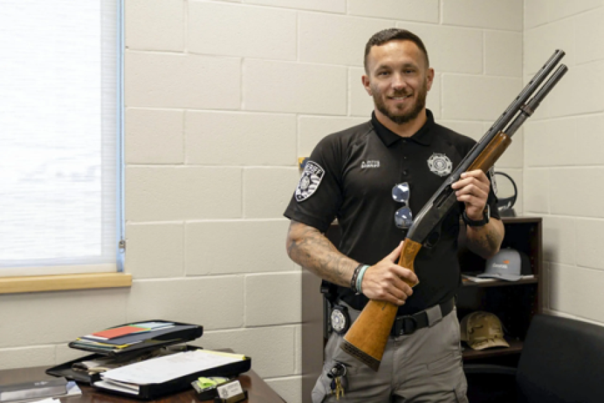 Kingfisher County Sheriff Aaron Pitts stands in his office with the gun initially labeled as missing in an audit by the State Auditor's Office.