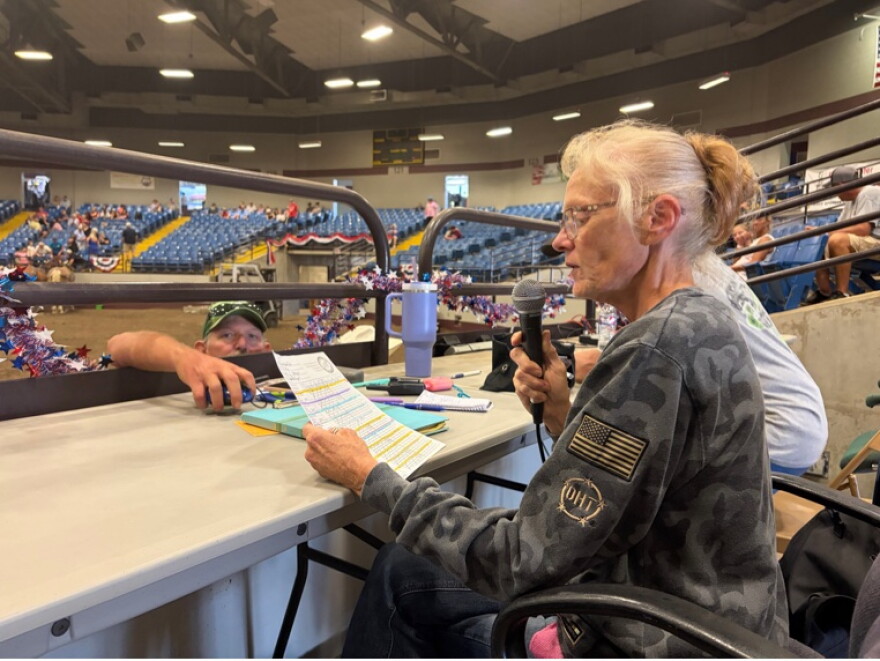 Susie Phillips sits at the announcer table.