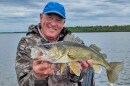 An angler holds a walleye on a lake in northern Minnesota.