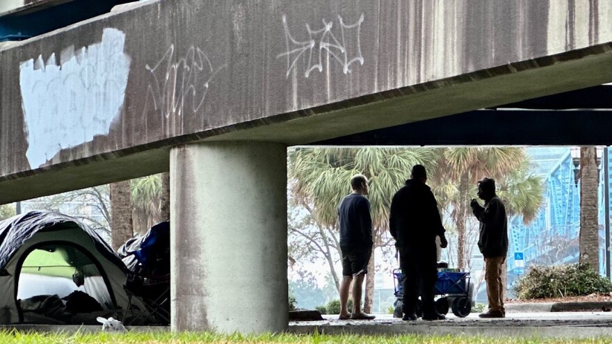 Unhoused men speaking near the north end of the Main St. bridge in Jacksonville.