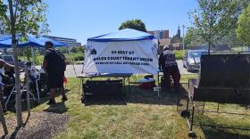 Noles Court resident Maurice Jones, right, chooses hot dogs and hamburgers for the grill during an event to discuss resident concerns.