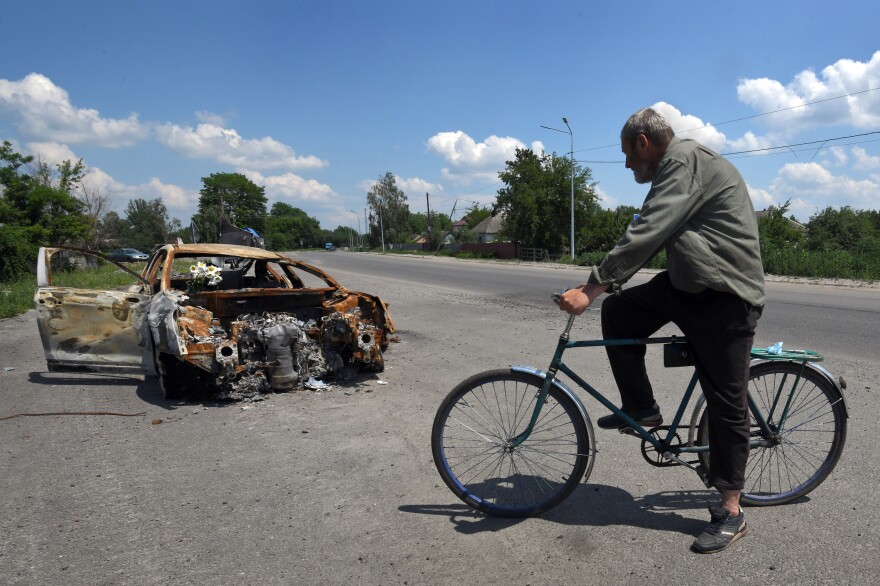 Oleksandr Breus, a Ukrainian and onetime French legionnaire, was killed next to his car during the Russian invasion. Oleksandr Holod, who says he witnessed it from his window, describes events as he rides his bike past the charred remains of the vehicle near Nova Basan, Chernihiv Oblast, Ukraine on June 28.