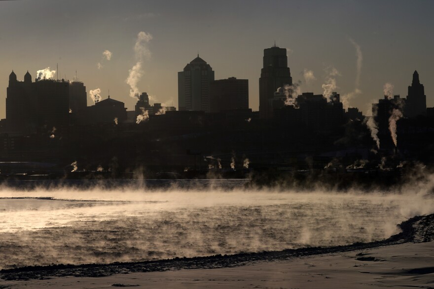 Downtown buildings stand in the distance while steam rises off the frozen Missouri River as the temperature hovers at -9 degrees Fahrenheit Tuesday, Feb. 16, 2021, in Kansas City, Mo. (AP Photo/Charlie Riedel)